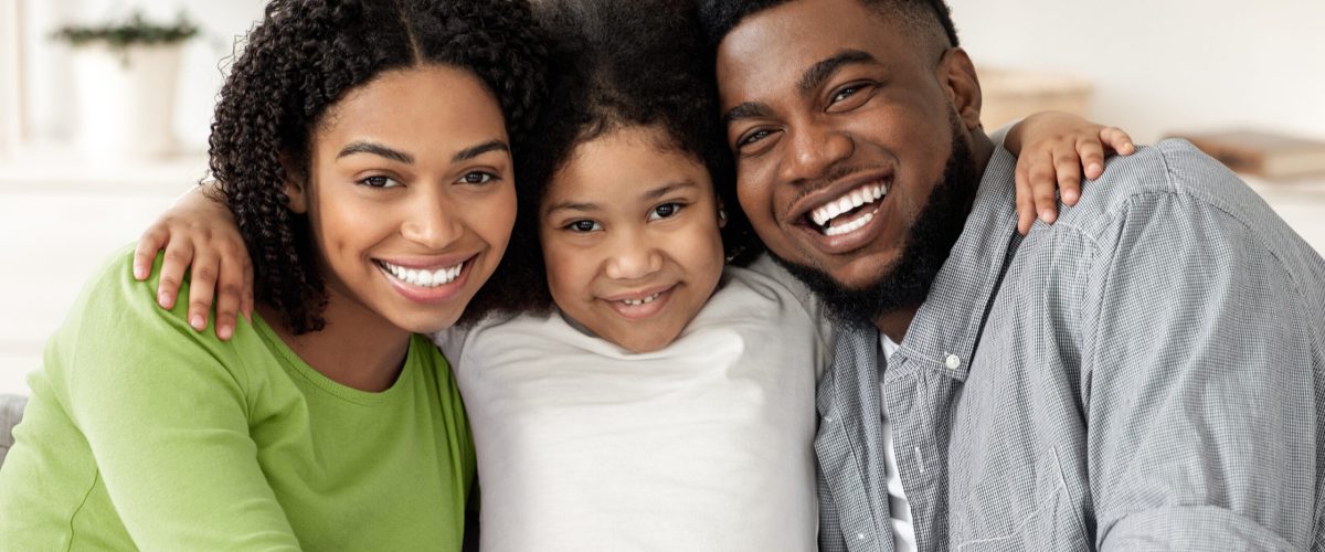 Happy African American Family Posing For Portrait At Home, Embracing And Smiling At Camera, Closeup